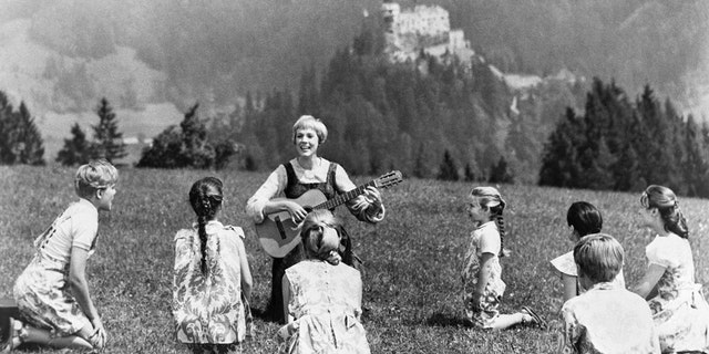 Julie Andrews playing guitar to her children castmates in The Sound of Music