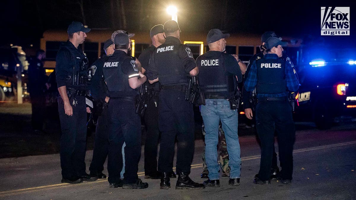 Police stand guard where the Lewiston shooter, Richard Card was found dead tonight