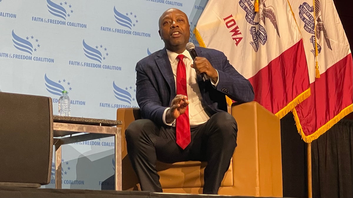 Sen. Tim Scott sits in front of Iowa flag