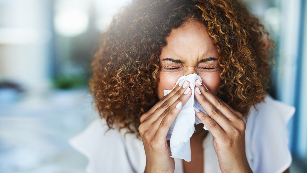 woman sneezes