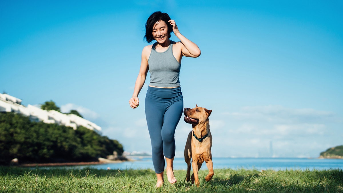 happy woman walking with dog