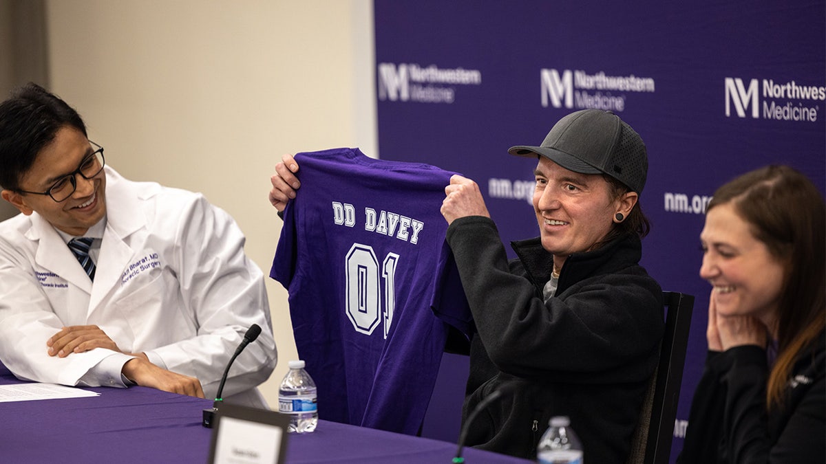 Davey holding up his "DD Davey" shirt