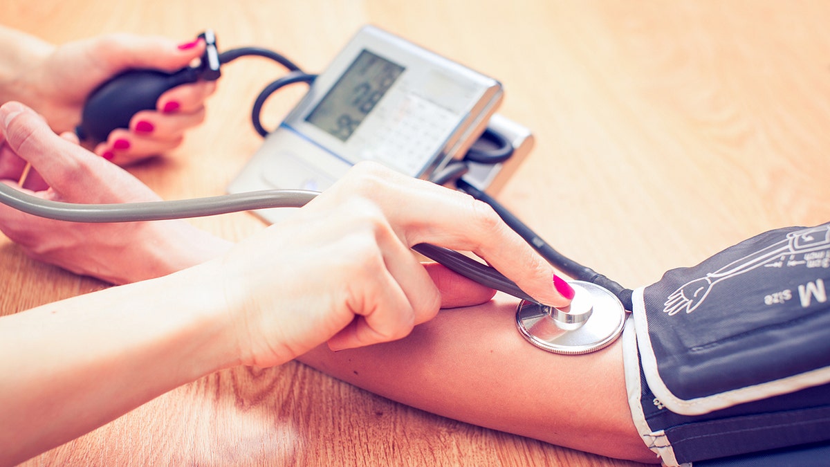 doctor checks patient's blood pressure