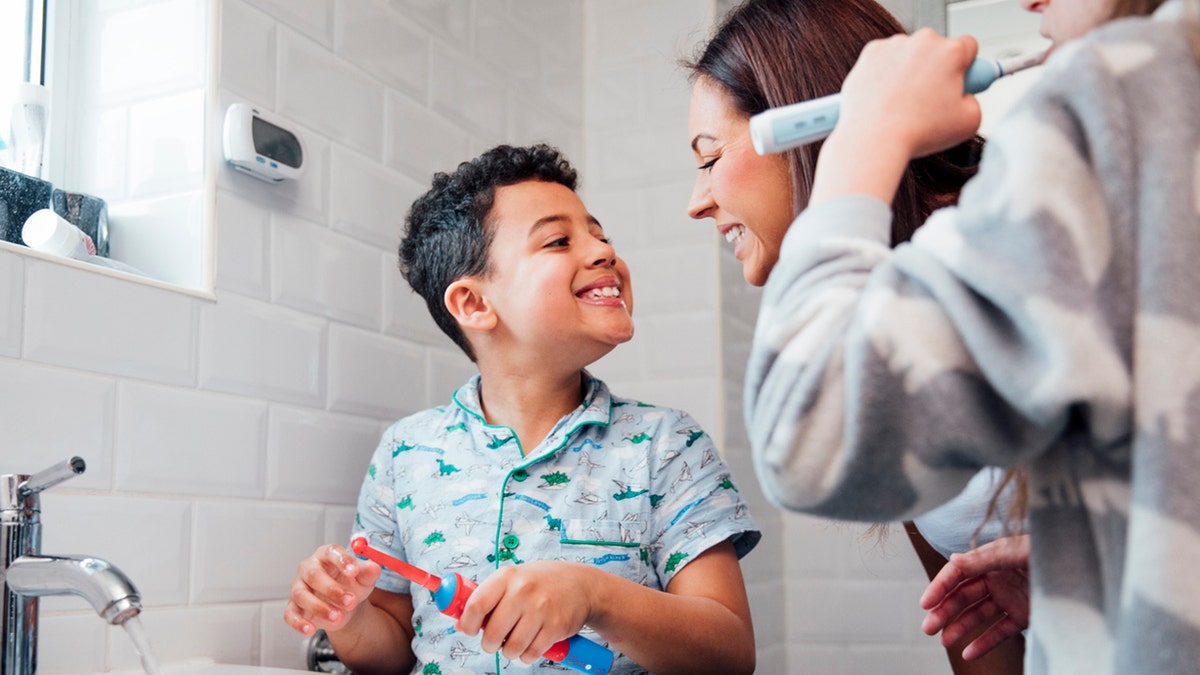 mother checks son's brushed teeth