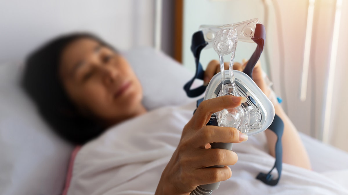 woman holds cpap machine