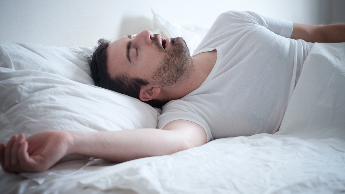 Man sleeping in his bed and snoring loudly