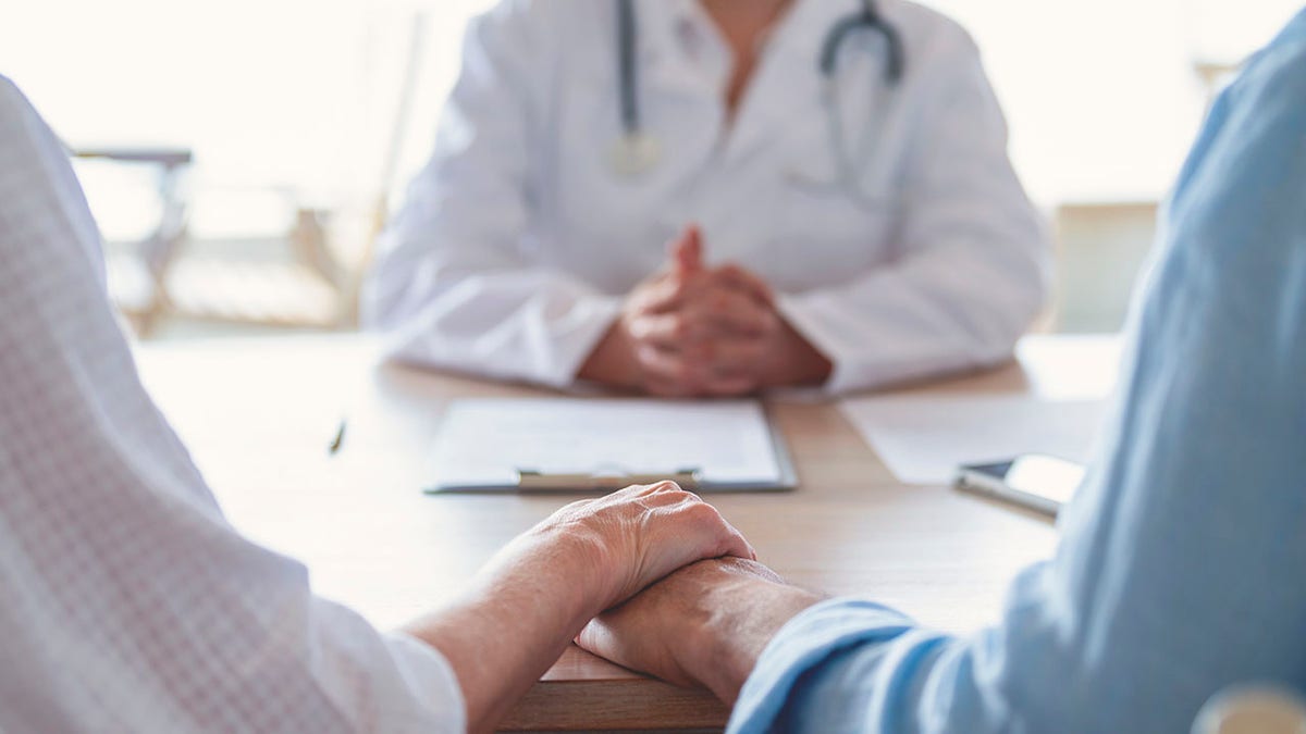 couple holds hands at appointment