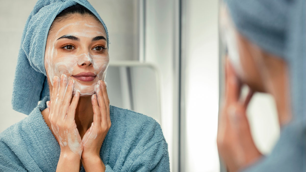 woman washing face with soap