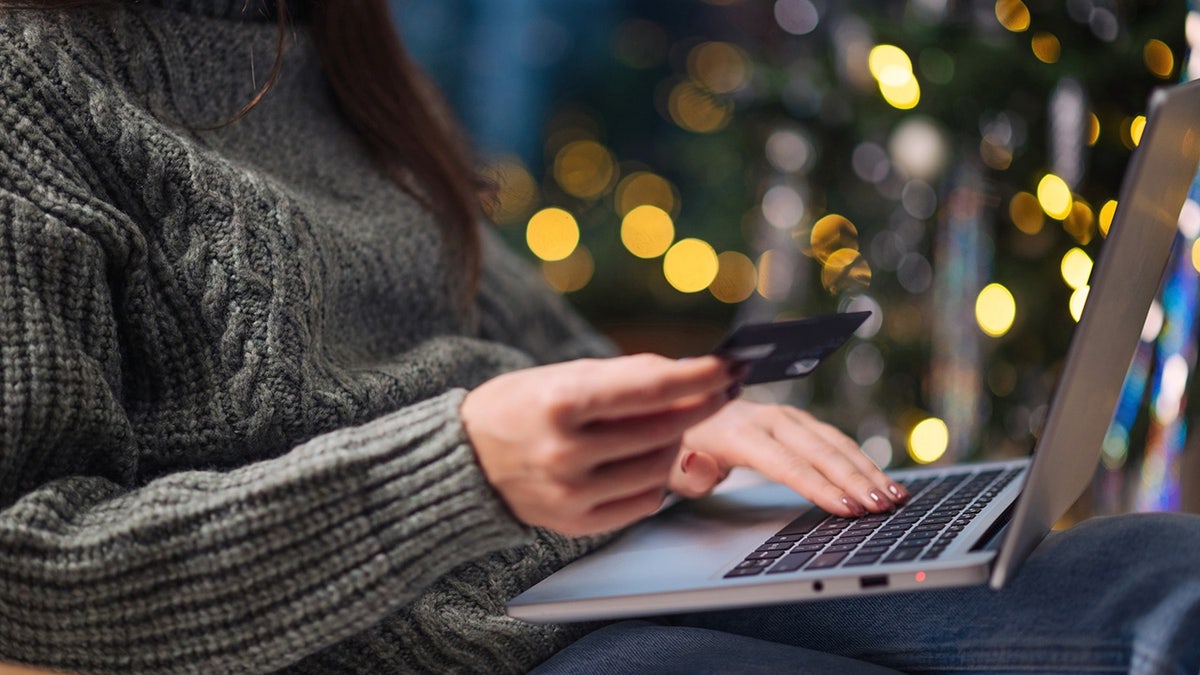 A woman typing in her credit card information online.