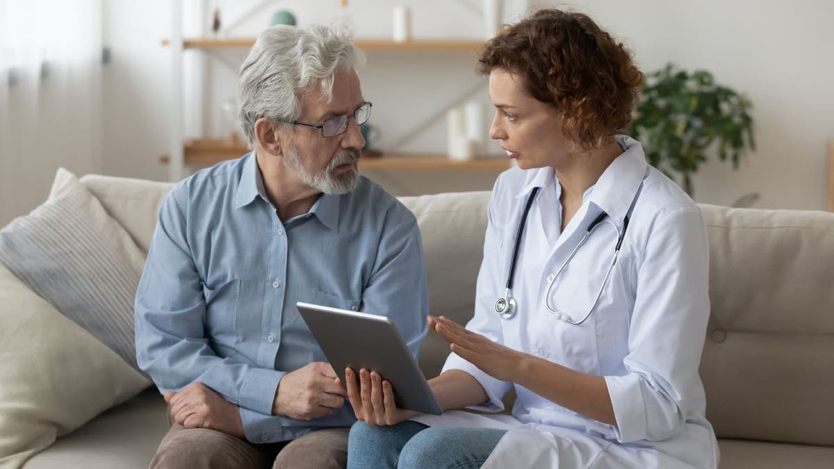 Elderly man speaking with doctor